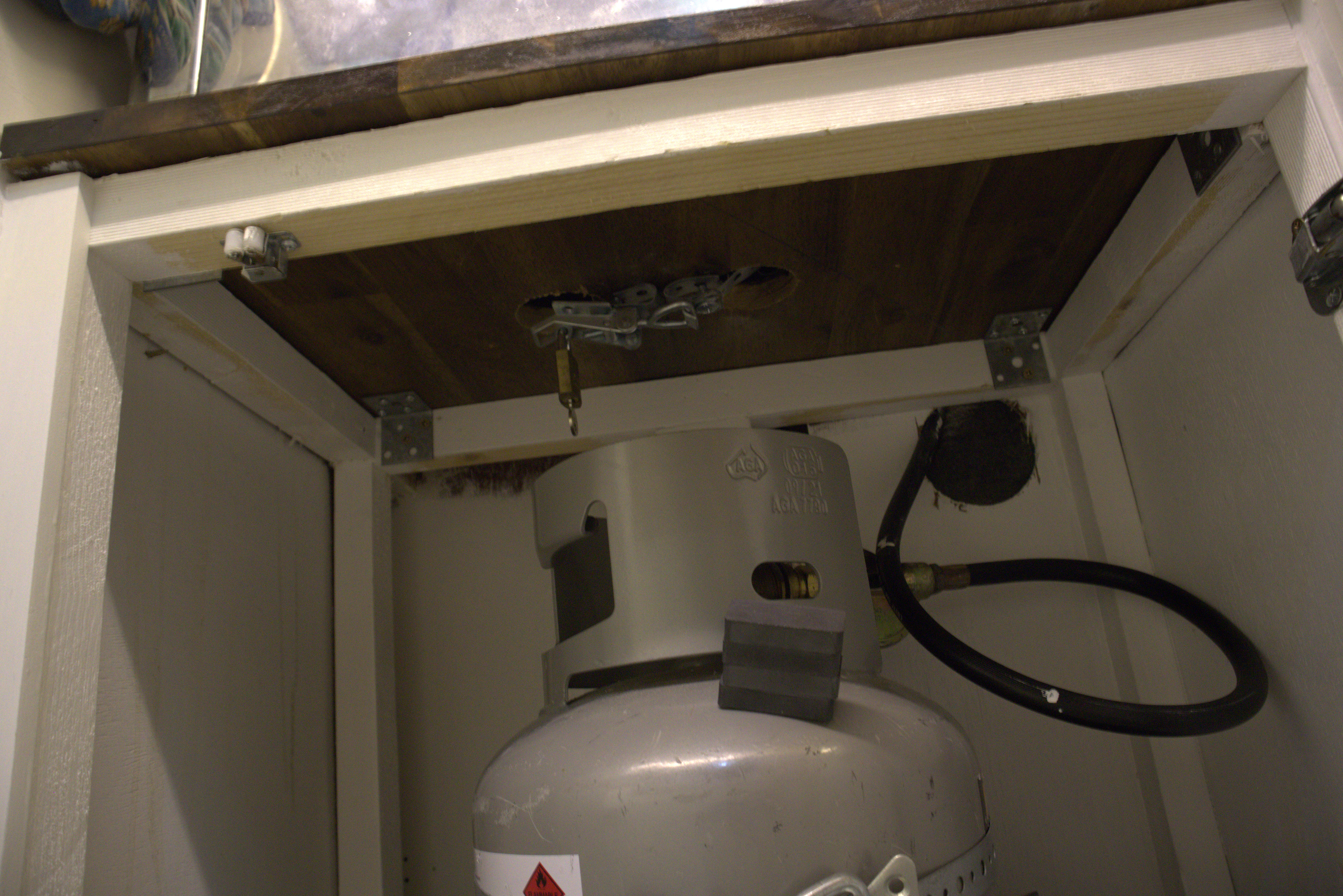 Gas bottle for the oven secured in cupboard with clasp